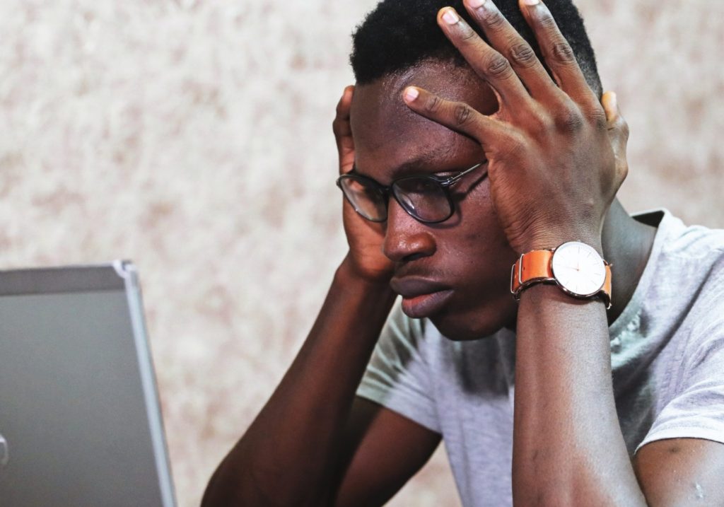 A man holding his head in regret for making mistakes in launching his online business